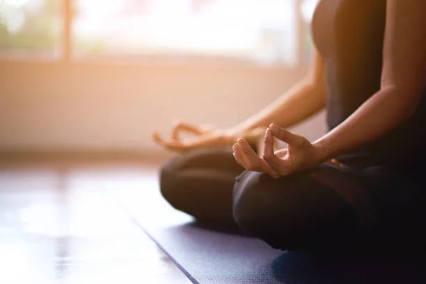 Hands resting in meditation in warm window light